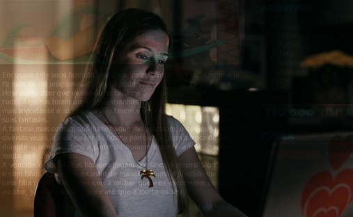 Deborah Secco sentada ao computador a blogar no filme "Bruna Surfistinha"